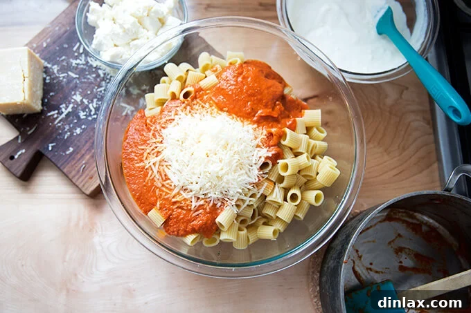A large mixing bowl containing al dente penne pasta, generously coated in the rich vodka sauce, and sprinkled with parmesan cheese.