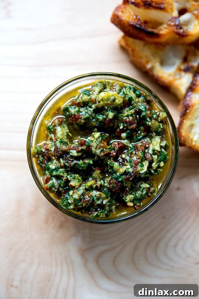 Sun-Kissed Tomato and Spinach Pesto Crostini 2 Vibrant Sun-dried Tomato and Spinach Pesto in a rustic bowl, accompanied by golden brown crostini and fresh bread slices.