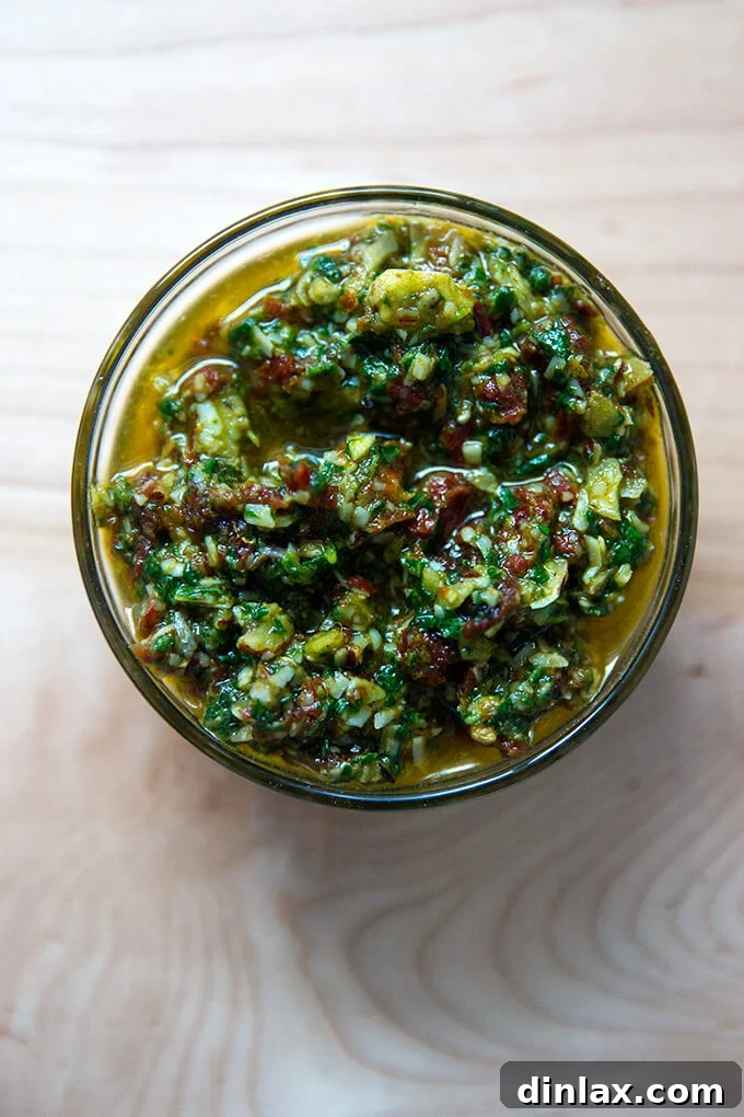 Sun-Kissed Tomato and Spinach Pesto Crostini 7 Overhead shot of a bowl filled with sun-dried tomato and spinach pesto, glistening with olive oil.