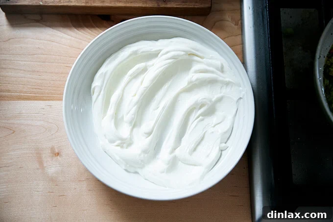 Wholesome Greek Yogurt Ranch Dip 8 Greek yogurt base artfully smeared onto a serving dish, creating swirls and valleys.