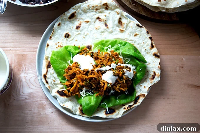 An overhead shot of a sweet potato and black bean burrito, unrolled.