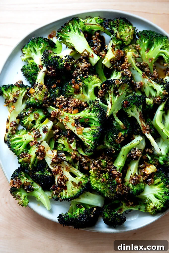 A stunning close-up of spicy broiled broccoli with sesame-scallion oil on a plate, showcasing the vibrant green and charred textures, ready for enjoyment.