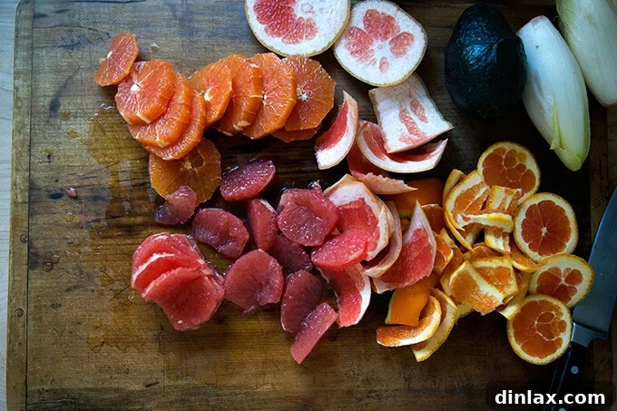 Peeled oranges and grapefruits on a cutting board, ready for segmenting and slicing.
