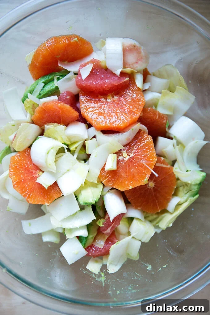 Citrus, avocado, and endive gently tossed in a bowl with sea salt.
