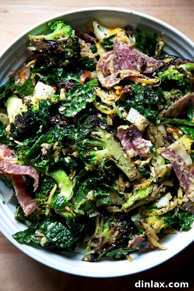 A vibrant bowl of Charred Broccoli Chopped Salad with creamy cashew dressing, featuring a mix of cooked and raw vegetables, salami, and cheese.