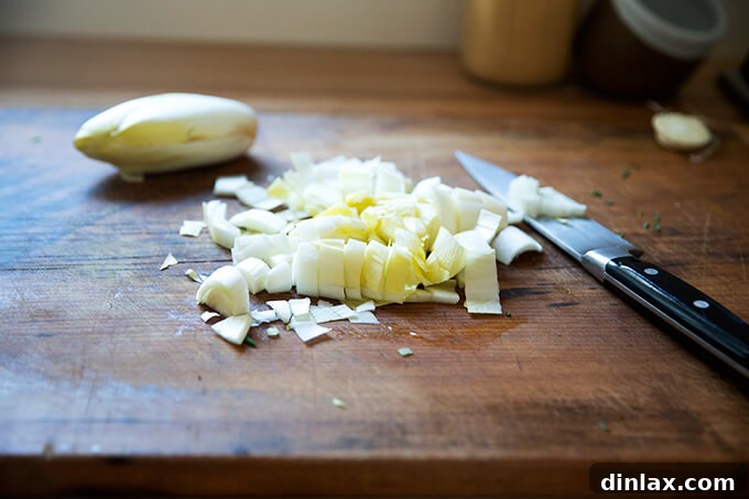 Crisp chopped endive on a cutting board, prepared for the salad.