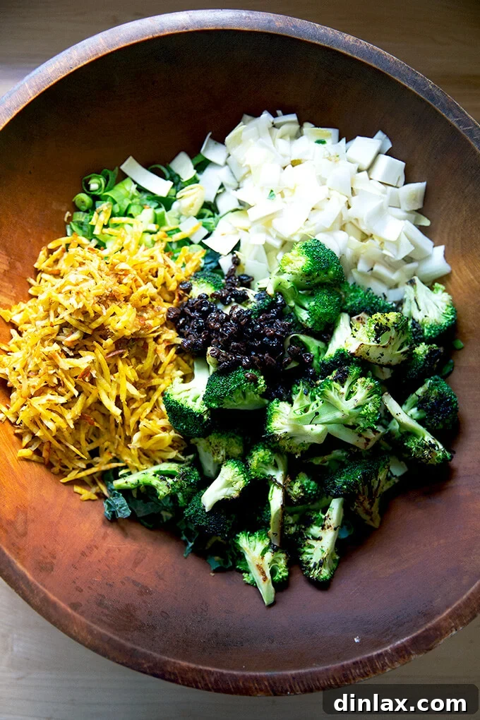 A large salad bowl filled with a colorful mix of chopped kale, endive, scallions, shredded beets, and vinegar-soaked currants.
