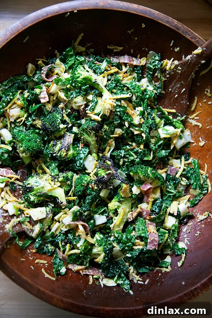 A large salad bowl with the Charred Broccoli Chopped Salad thoroughly tossed with the spicy cashew dressing, ready to serve.