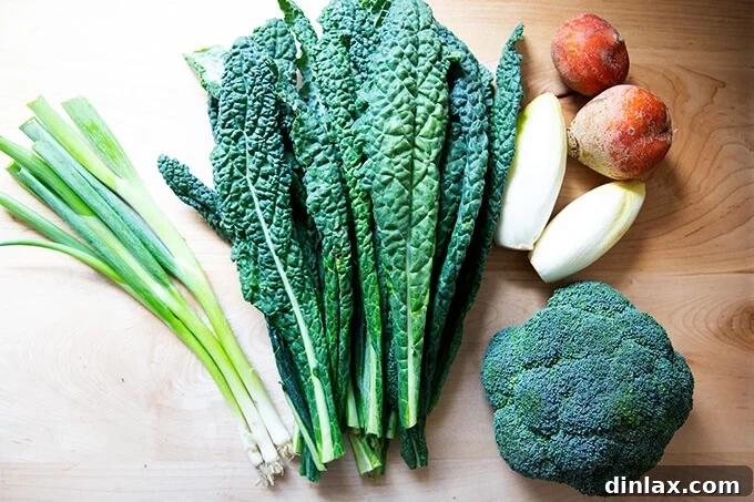 Assortment of fresh vegetables for the chopped salad: scallions, Tuscan kale, Belgian endive, golden beets, and broccoli florets.