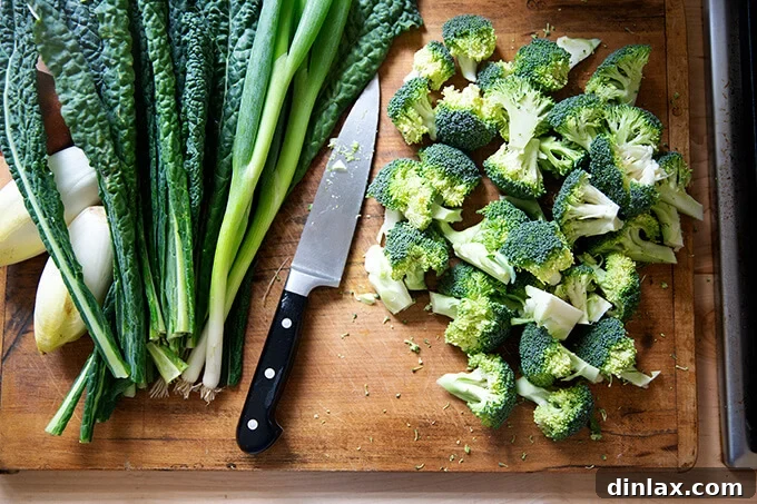 A cutting board with uniformly chopped broccoli florets, ready for charring.