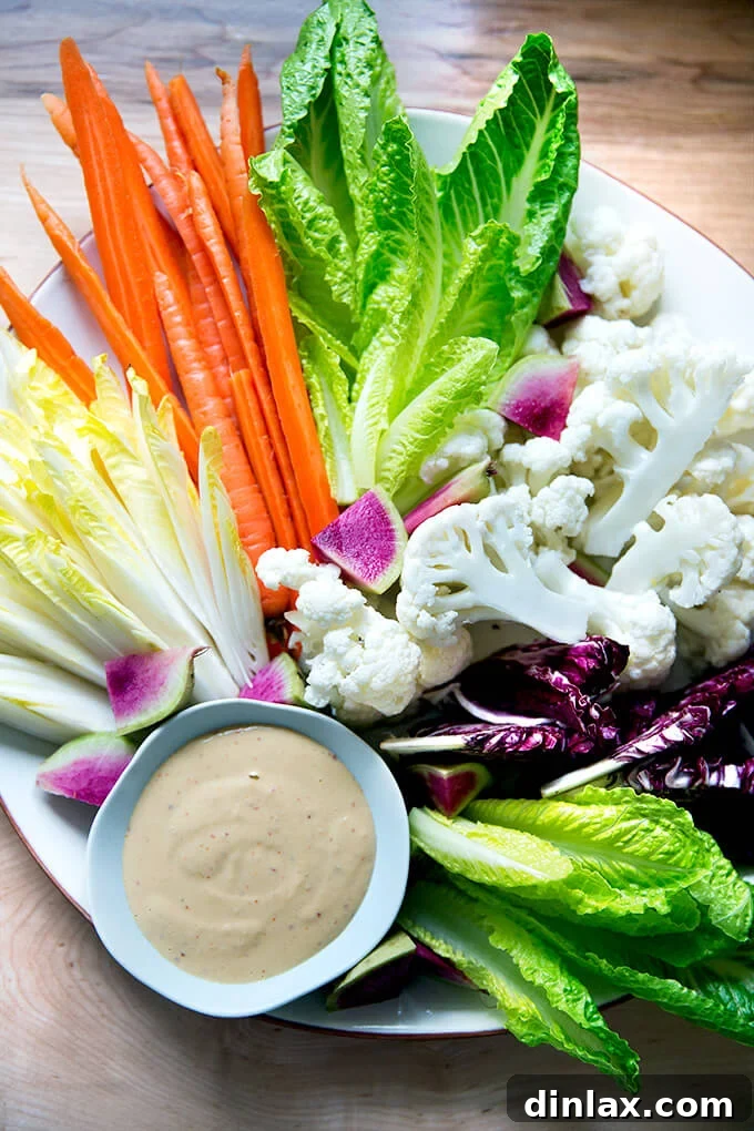 A vibrant platter of pickled and fresh crudités with a rich, spicy cashew dip, perfect for entertaining.