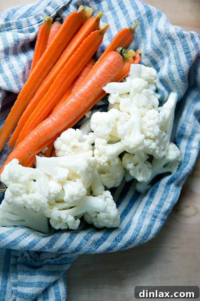 Pickled carrots and cauliflower being lightly dried with a tea towel before plating.