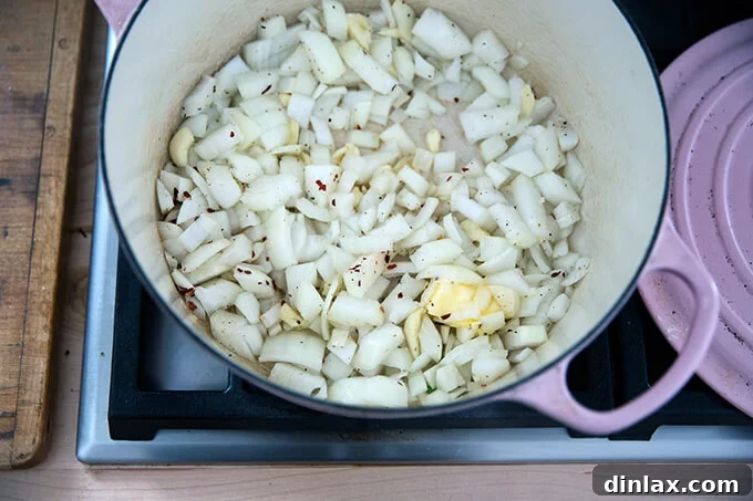 Golden Cheddar Broccoli Bisque 4 Onions, garlic, crushed red pepper flakes, and melting butter are gently sweating in a Dutch oven, creating the aromatic base for the soup.