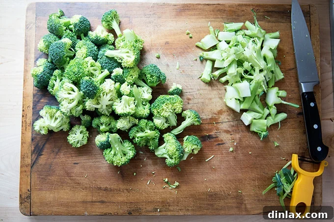 Golden Cheddar Broccoli Bisque 5 A cutting board displays neatly trimmed broccoli florets and their stalks, ready for chopping and use in the soup.
