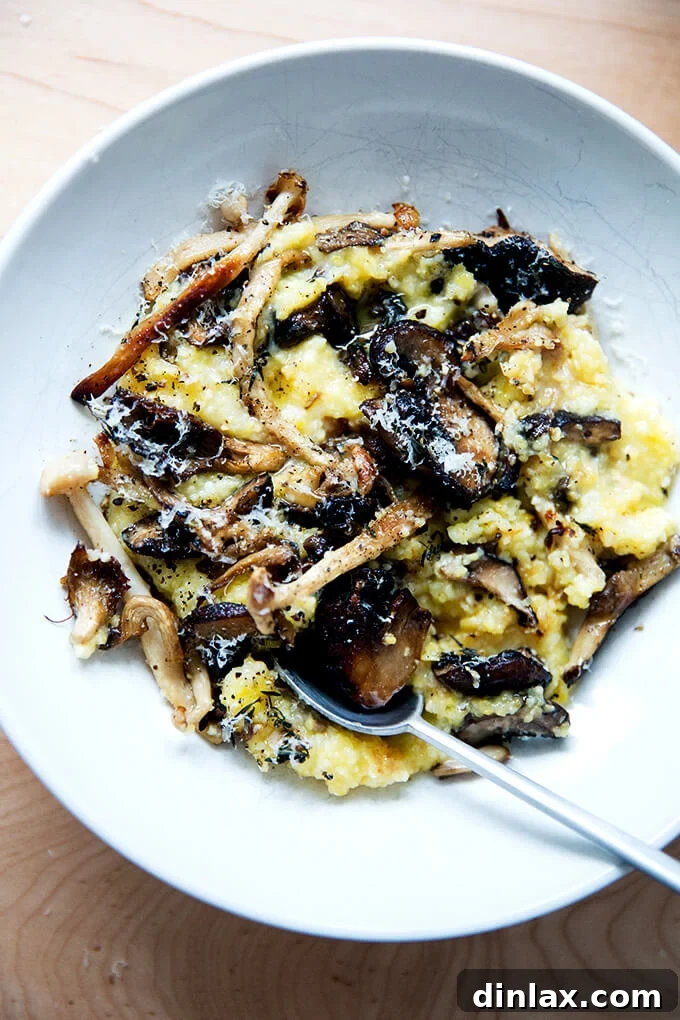 A deep bowl of roasted mushroom polenta bake, perfectly portioned, with a spoon resting in it, inviting you to take a bite.