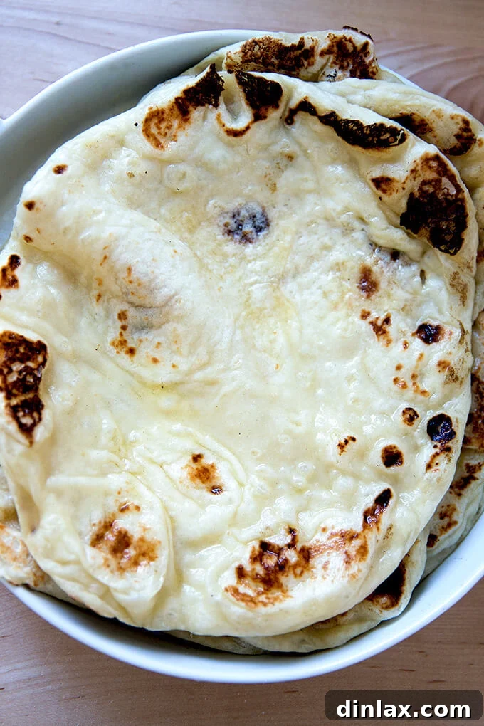 A platter brimming with freshly made, golden-brown naan, ready for a feast.
