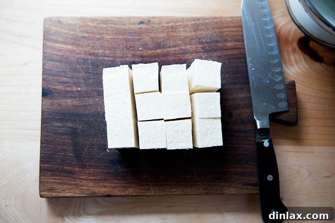 A block of firm tofu, perfectly cut into 1-inch cubes.