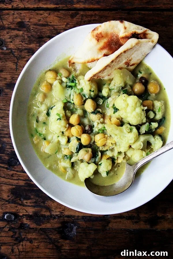 10 Essential Chickpea Recipes You Need Today 7 A pot of vibrant curried chickpeas with tender cauliflower florets and creamy coconut milk, simmering to perfection.