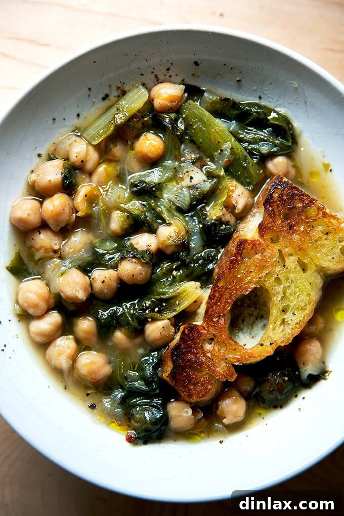 A comforting bowl of homemade chickpea and escarole soup, served with crusty olive oil toasted bread.