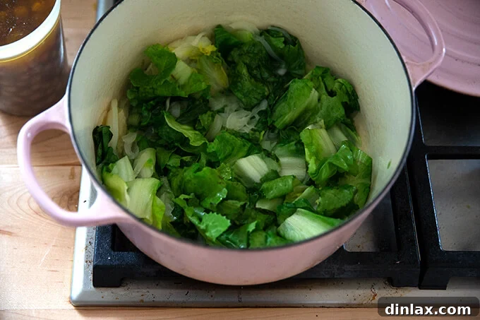 The escarole has beautifully wilted down into the onions, making space for the remaining soup ingredients.