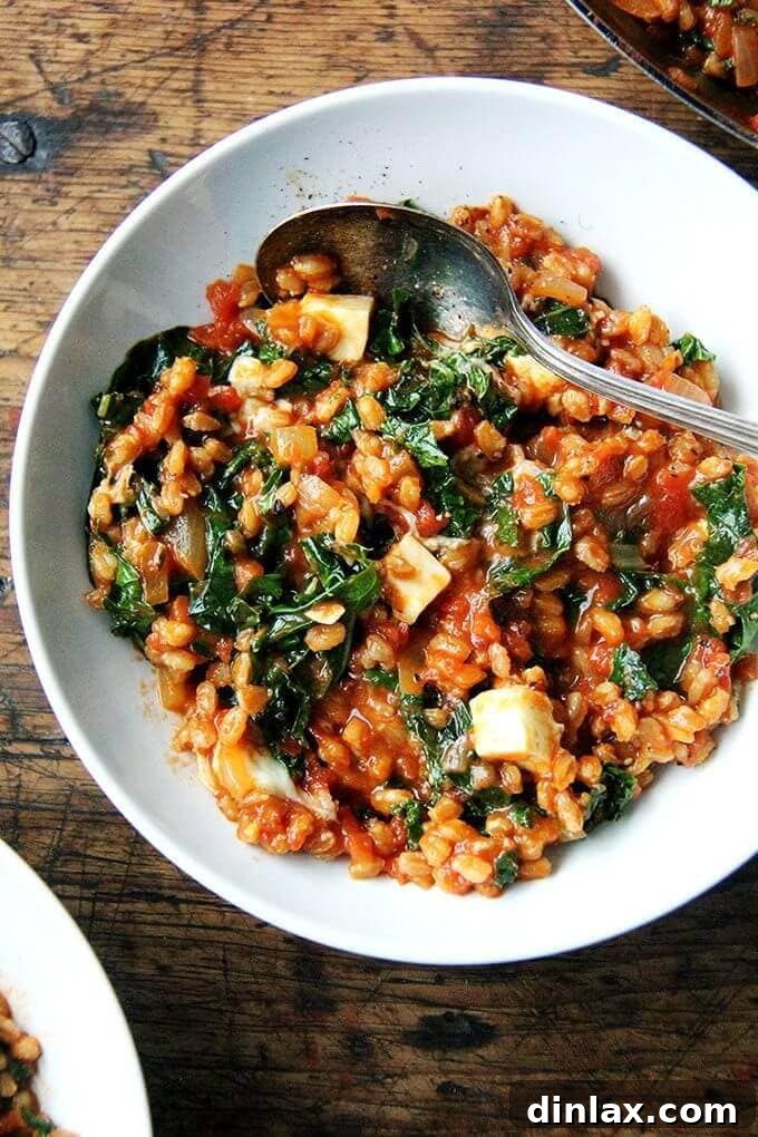 Ottolenghi's inspired farro risotto with tomatoes and kale, featuring feta and smoked paprika.