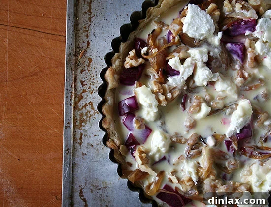 Unbaked beet, goat cheese, and walnut tart, showcasing the vibrant filling before baking.