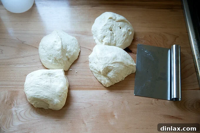 Unlock the Best Sourdough Pizza Crust 11 Portioned sourdough pizza dough aside a bench scraper.