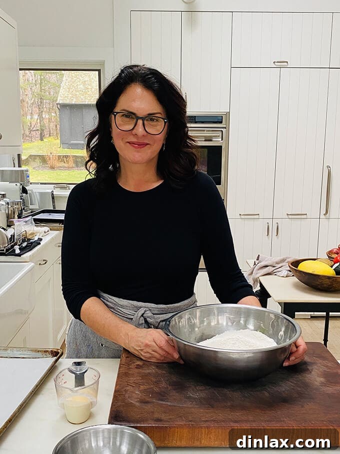 Susan Spungen in her kitchen, holding her cookbook with a warm smile, ready to share her culinary wisdom.