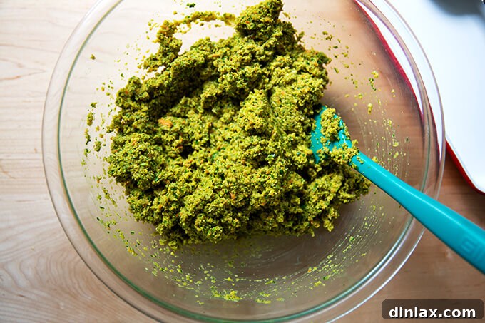 The falafel burger mix in a bowl, stirred together after eggs have been added, showing a cohesive texture.