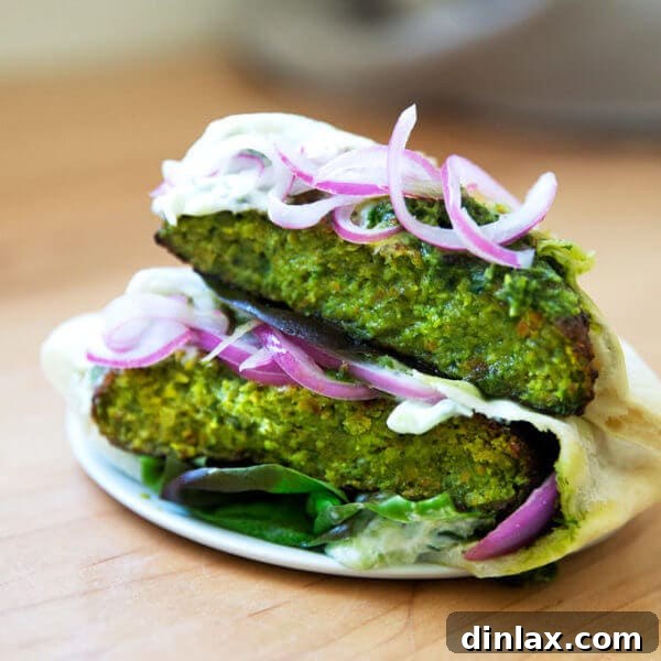 A vibrant, golden-brown falafel burger on a white plate, ready to be served.