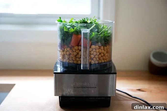 All falafel burger ingredients placed into a food processor, ready to be pulsed into a cohesive mixture.