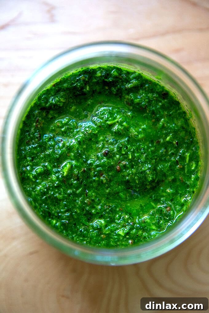 A jar of schug, a vibrant green, herby, and spiced Middle Eastern condiment.