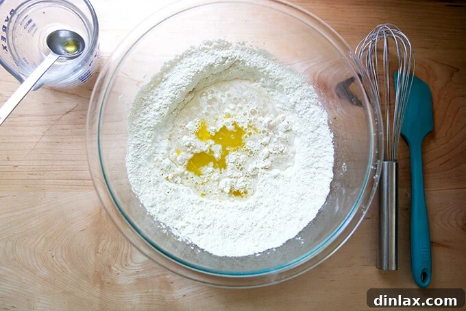 Your Guide to Irresistible Homemade Pita 9 Liquid ingredients being added to dry ingredients for pita bread.