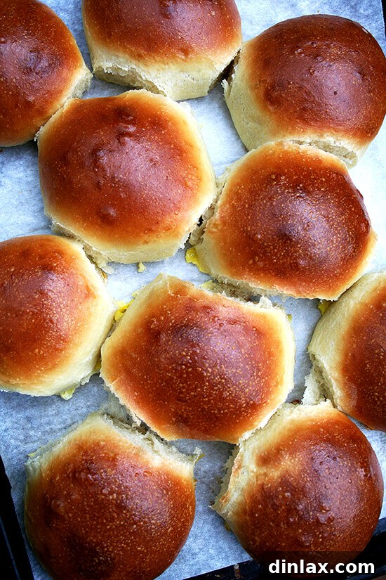 The secret to an unforgettable burger: perfectly baked light brioche buns. Golden brown homemade brioche hamburger buns cooling on a wire rack, perfect for a gourmet burger experience.