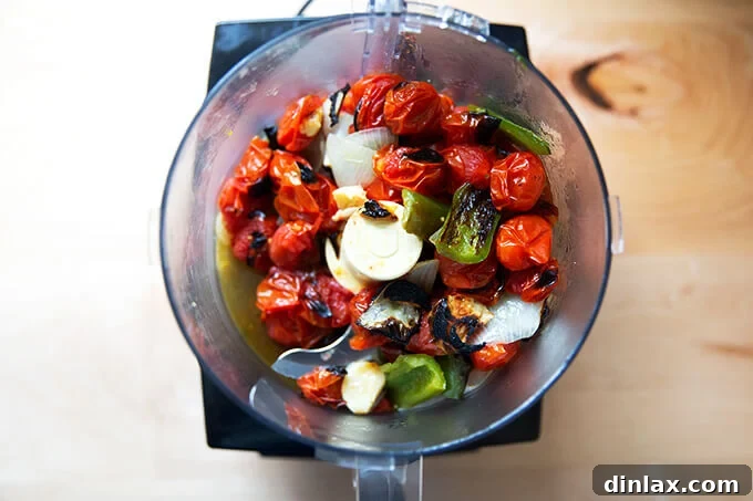 Effortless Homemade Red Enchilada Sauce 6 Broiled vegetables, still warm and fragrant, have been transferred into a food processor, poised for blending into a delicious sauce.