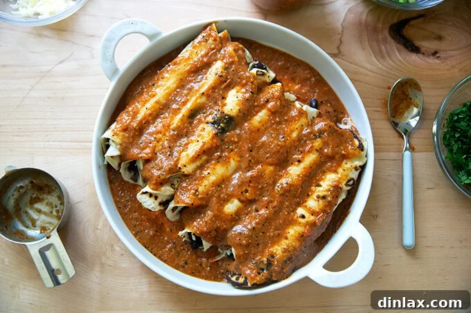 Ultimate Vegetarian Bean and Cheese Enchiladas 7 A baking dish filled with enchiladas, completely smothered with a rich, red enchilada sauce.