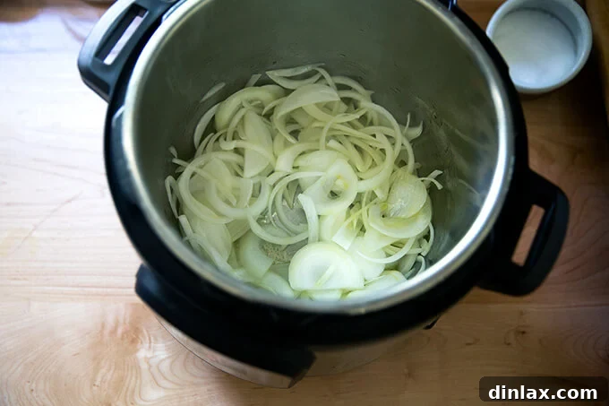 Smoky Instant Pot Chicken Tinga 5 An Instant Pot filled with sautéed onions.