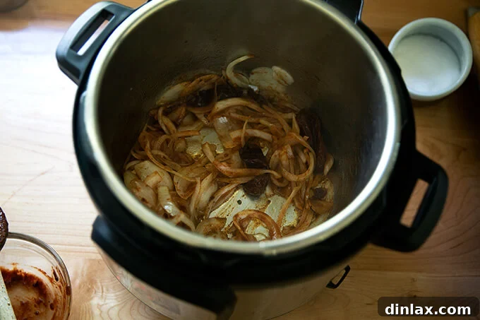 Smoky Instant Pot Chicken Tinga 6 An Instant Pot filled with sautéed onions and chipotle in adobo sauce.