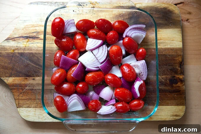 A pan of tomatoes and onions, tossed with olive oil and salt.