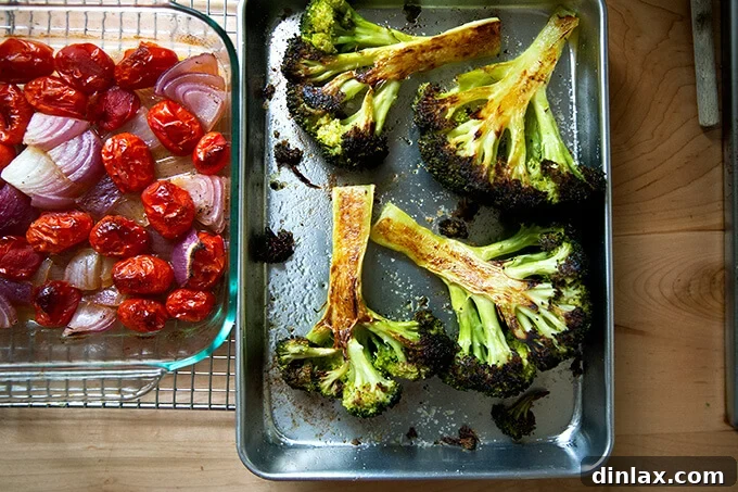 Two pans: one holding roasted tomatoes and onions; the other holding roasted broccoli.
