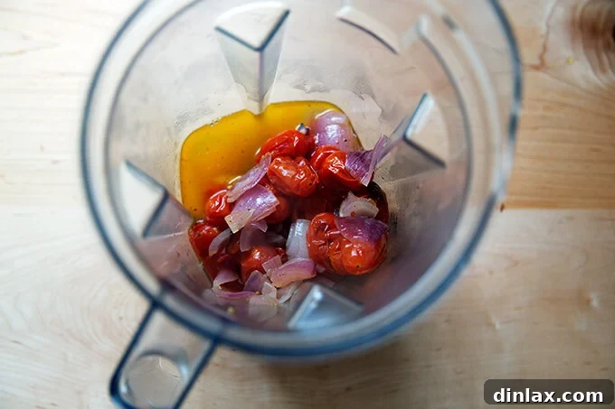 A blender filled with roasted broccoli and onions.