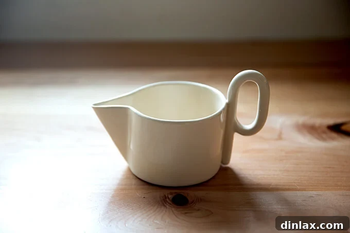 A modern, handmade ceramic loop gravy boat, perfect for elegant serving.