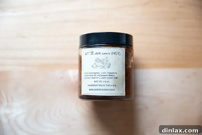 A jar of Vietnamese Saté chili sauce, known for its intense heat and rich flavor.