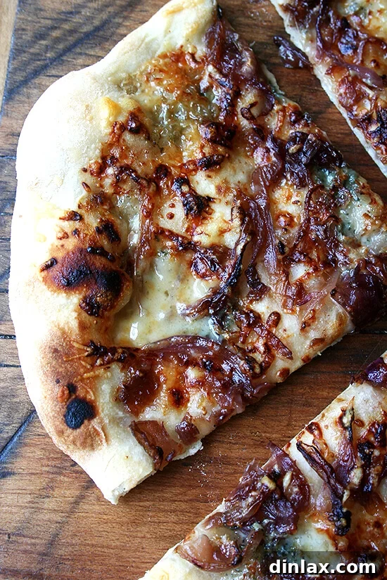 Close-up of a homemade fig jam, caramelized onion, and blue cheese pizza showcasing the crispy crust.
