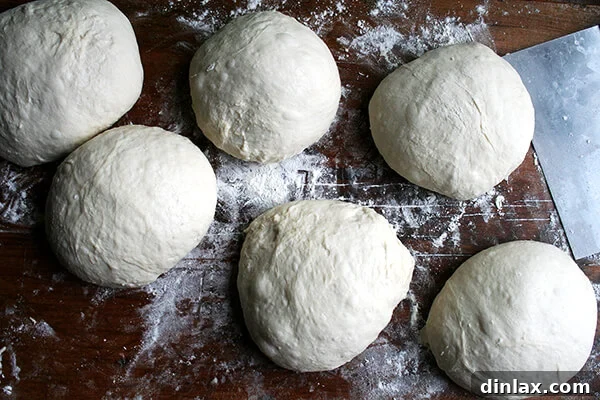 Smooth, round pizza dough balls, perfectly shaped for baking.
