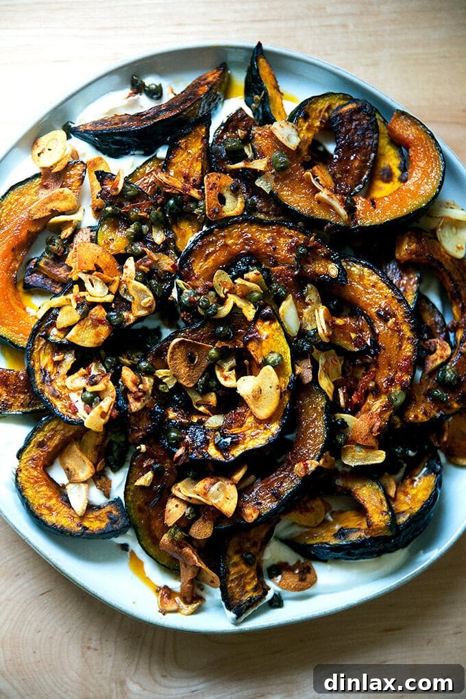 A plate of roasted Kabocha squash atop lemony yogurt sauce and sizzling garlic, capers, and Calabrian chili paste.