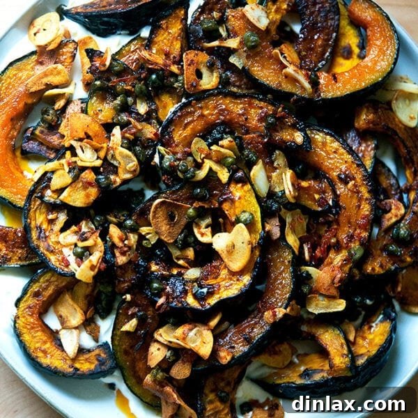 A plate of roasted Kabocha squash atop lemony yogurt sauce and sizzling garlic, capers, and Calabrian chili paste.