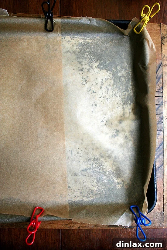 Pan Clipped with Parchment Parchment paper neatly clipped to a baking pan, ready for batter.
