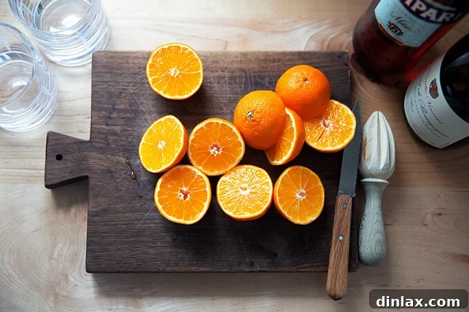 Halved clementines arranged neatly on a wooden cutting board, ready for juicing.