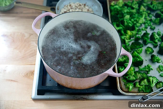 A large pot of water boiling, with quinoa simmering, showing the light grains cooking.